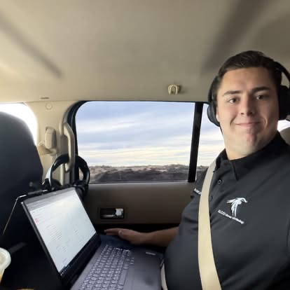 Adam Leveille working from a laptop while traveling as a passenger.