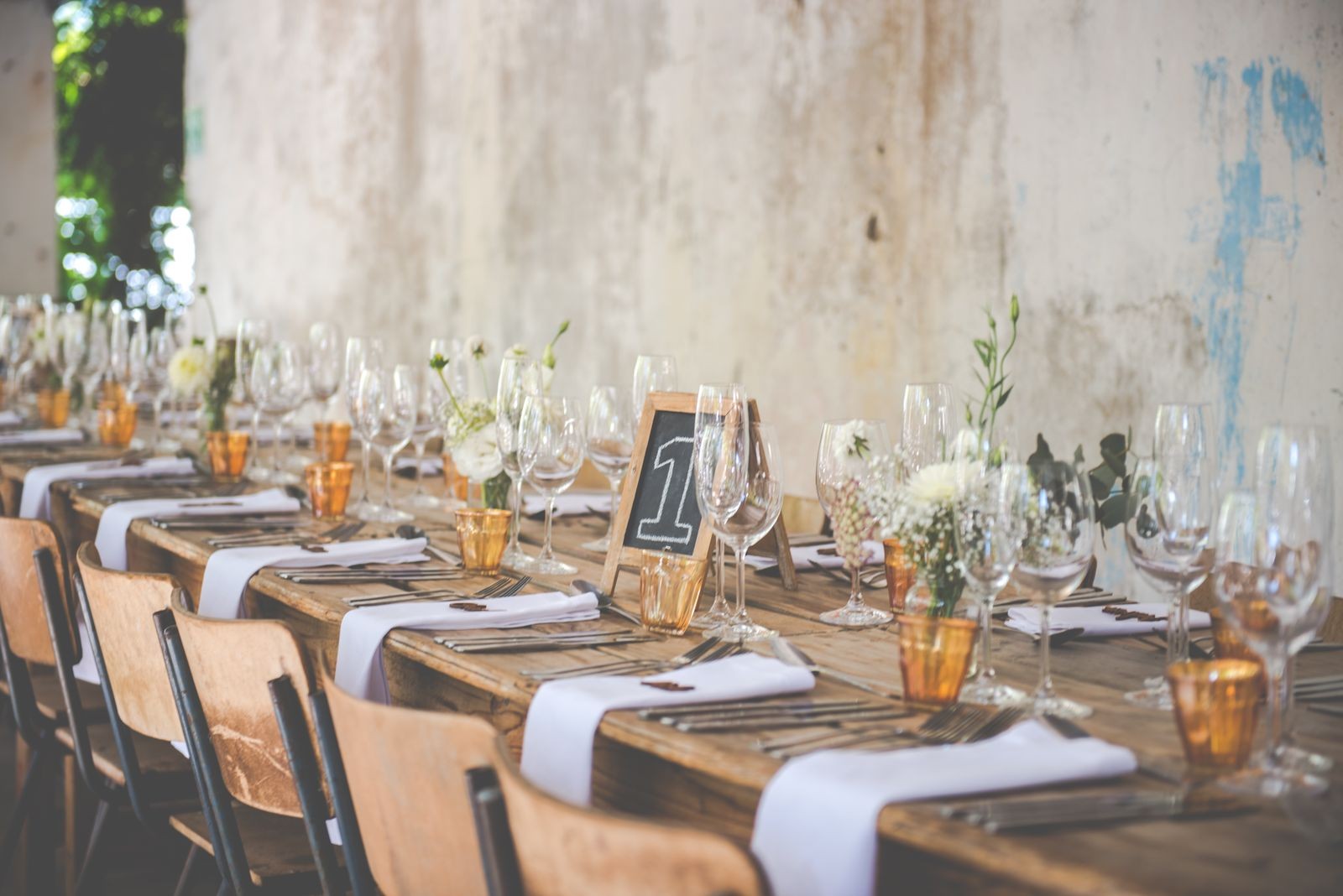A reception table set with glassware and flowers.